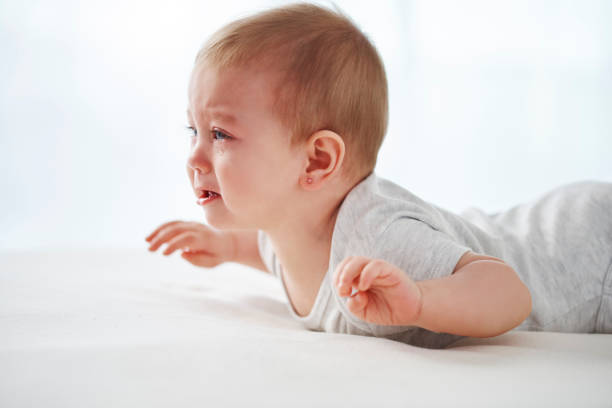 istock Crying baby lying on the bed 1138809942