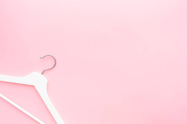 istock White hangers on pastel pink background 1138810780
