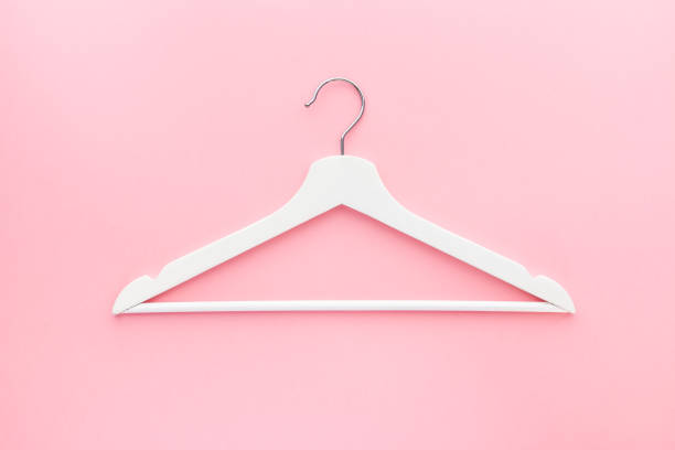 istock White hangers on pastel pink background 1138810892