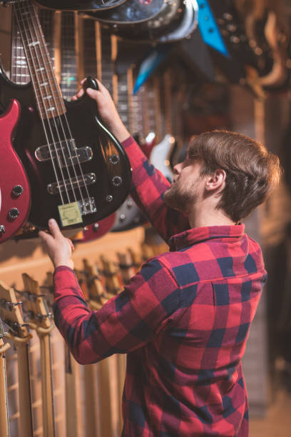 istock Young musician choosing a bass guitar 1138813643