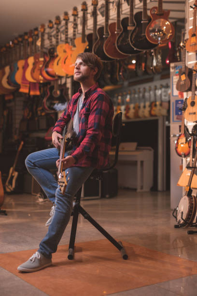 istock Young man playing the guitar indoors 1138813663