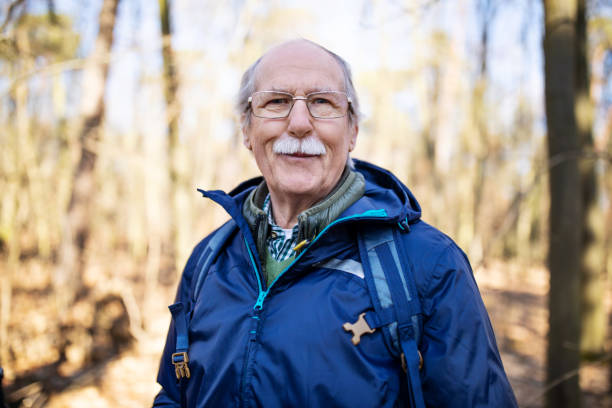 Senior man on a hiking trip Portrait of senior man on a hiking trip in nature. Senior man with backpack standing in the forest. grunewald berlin stock pictures, royalty-free photos & images