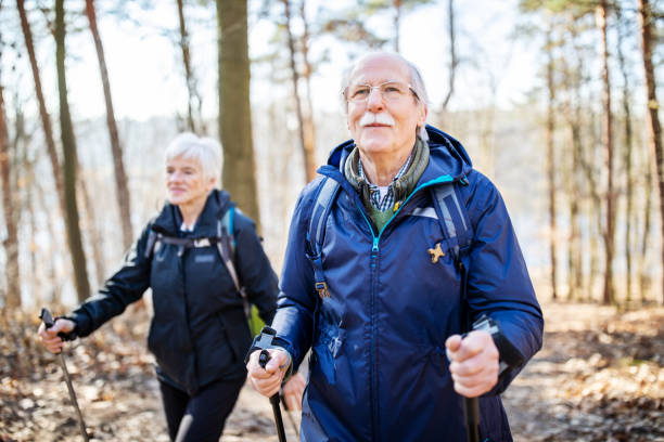 starszy mężczyzna wędrówki z przyjacielem - nordic walking zdjęcia i obrazy z banku zdjęć