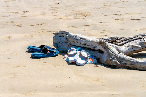 Log on the beach with flip flops left while swimming in the sea in Thailand.
