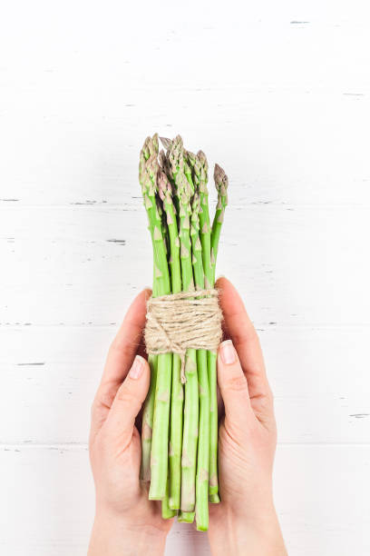istock Fresh green asparagus in woman hands 1138814345