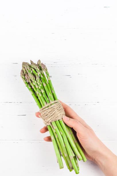 istock Fresh green asparagus in woman hands 1138814378