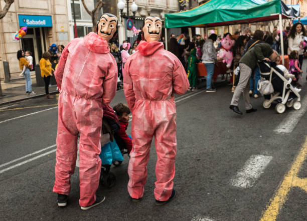 Alicante, Spain, - February 03, 2019: On Rambla de Alicante street and it’s carnival time. Festival time is deep rooted in Alicante’s culture comprising of street parties, with its spectacular finale on Sábado Ramblero. Fun is the theme of this day when thousands of people come to Alicante dressed in their most original, quirky or lavish traditional, gala garments, exchanging their daily outfits for those of superheroes, princesses, wizards, fairies, infants, older people, trolls or zombies. Alicante Carnival is one of the most highly participated carnivals in the Valencian Community. The carnival takes place every year in the first week of March. They have costume from the spanish serial which name is La Casa del Papel.