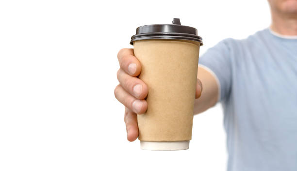 istock Hand holding and offers brown paper coffee cup on white 1138815840
