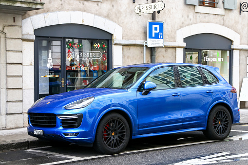 Geneva, Switzerland - March 13, 2019: Blue motor car Porsche Cayenne in the city street.