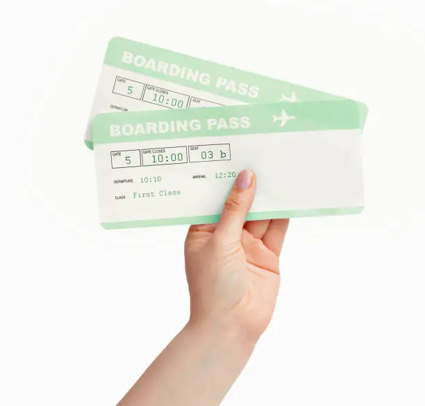 Woman hand holding a airline boarding pass isolated on a white background