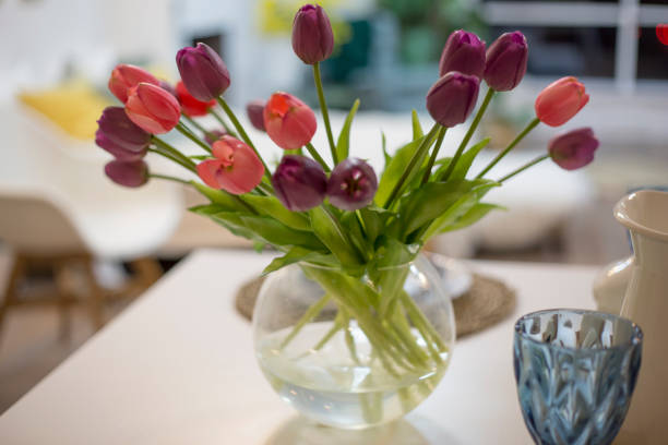 istock bouquet of multi-colored fresh tulips in a vase on a light background 1138821010