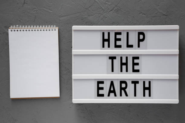 istock 'Help the Earth' words on modern board, blank notepad over concrete background, top view. Flat lay, overhead, from above. 1138821193
