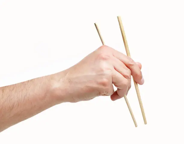 Cropped shot of an unrecognizable man hand using a chopsticks isolated on a white background