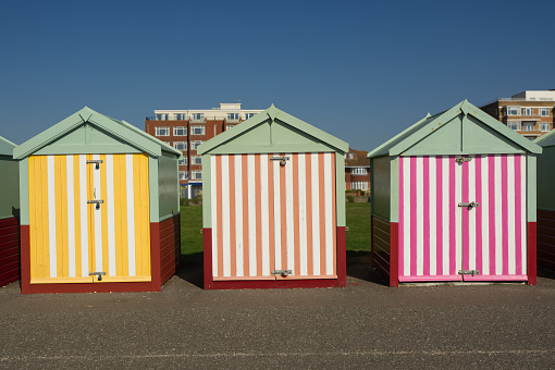 Colourful beach huts on the seafront promenade at Hove, Brighton, East Sussex, England