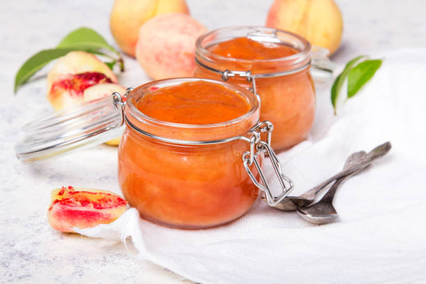 homemade peach jam with organic fruit. sweet preserves on a light background, copy space - preserves jar apricot marmalade imagens e fotografias de stock