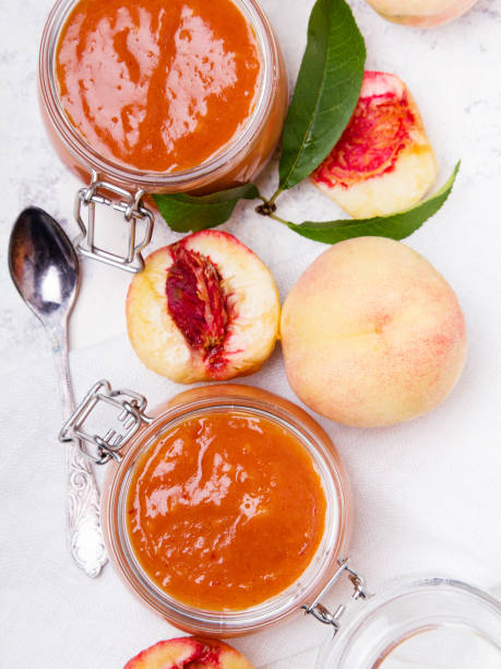 домашнее персиковое варенье с органическими фруктами. сладкие консервы на светлом фоне, копирование пространства - preserves jar apricot marmalade стоковые фото и изображения