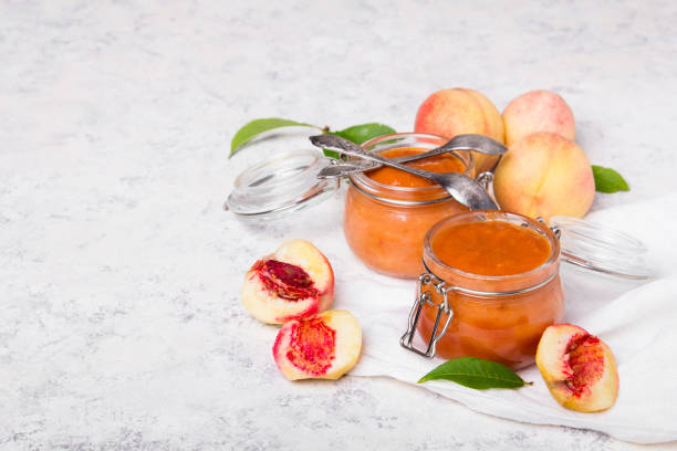 homemade peach jam with organic fruit. sweet preserves on a light background, copy space - preserves jar apricot marmalade imagens e fotografias de stock