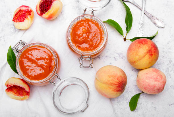 homemade peach jam with organic fruit. sweet preserves on a light background, copy space - preserves jar apricot marmalade imagens e fotografias de stock