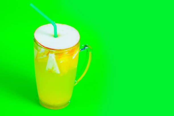 tea with apple and cocktail tube on a green background.