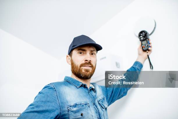 Handyman Checking Of Air Ventilation Stock Photo - Download Image Now - Quality Control, Wind, Indoors