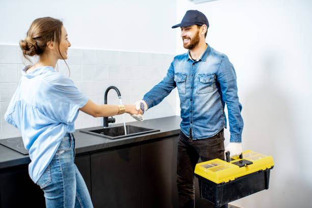 Handy man with woman on the kitchen Handy man having a deal with young woman client after the repairment on the kitchen. Home repair service concept Plumber stock pictures, royalty-free photos & images