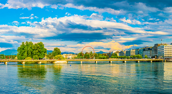 People are crossing a bridge over river Rhone in the swiss city Geneva, Switzerland