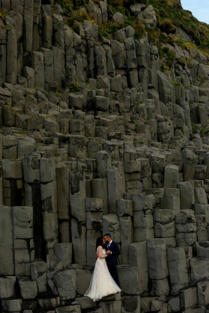istock Handsome groom and beautiful bride posing on rocks 1138824322