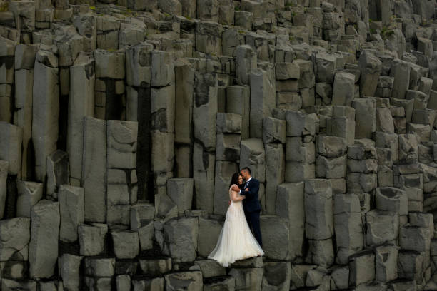 istock Handsome groom and beautiful bride posing on rocks 1138824333