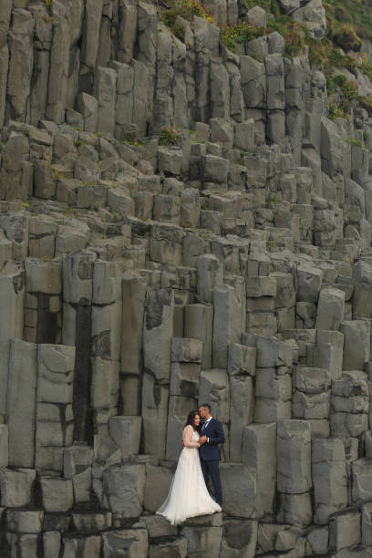 istock Handsome groom and beautiful bride posing on rocks 1138825149