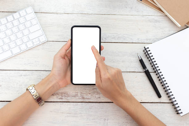 istock hand woman using a telephone, empty screen smart phone and computer on wooden table In home office. with clipping path 1138826735