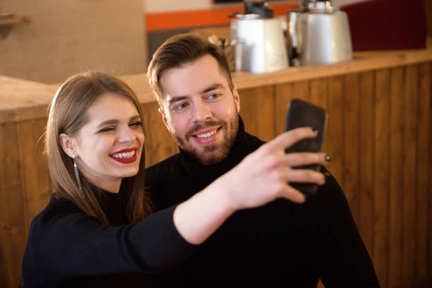 istock Smiling Woman And Handsome Man Drinking Coffee, Using Mobile Phone While Spending Time In A Coffee Shop. 1138826924