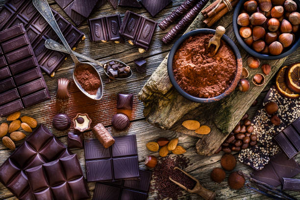 istock Chocolate assortment on cocoa powder shot from above on rustic wooden table 1138829890