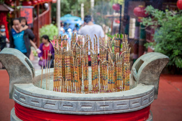 China, Hainan Island, Sanya, - December 1, 2018: White GuanYin statue in Nanshan Buddhist Cultural Park,Burning incense sticks. A close up of burning incense sticks, editorial.