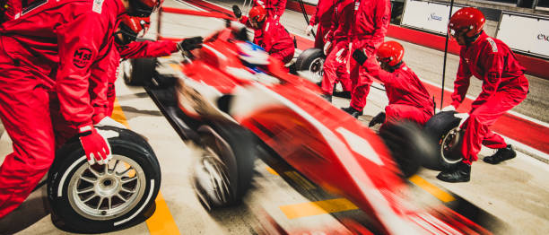 rote formel rennwagen aus der grube - motorsport veranstaltung stock-fotos und bilder