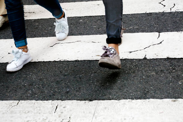 Young women's legs walking on a crosswalk in summertime in A Coruna, Galicia, Spain.