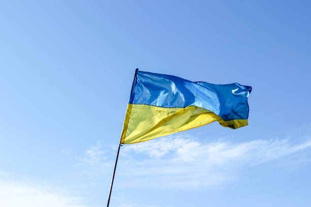 istock Waving Ukrainian yellow-blue flag against a blue sky 1138837880