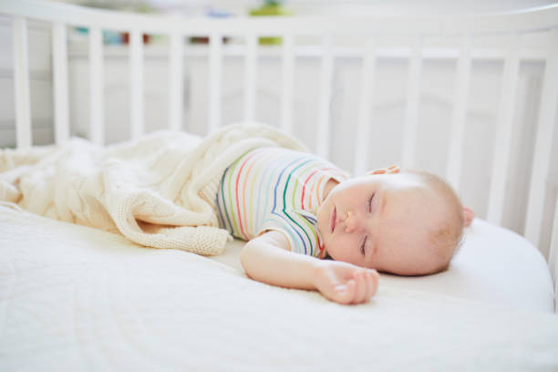 istock Baby sleeping in co-sleeper crib attached to parents' bed 1138839182