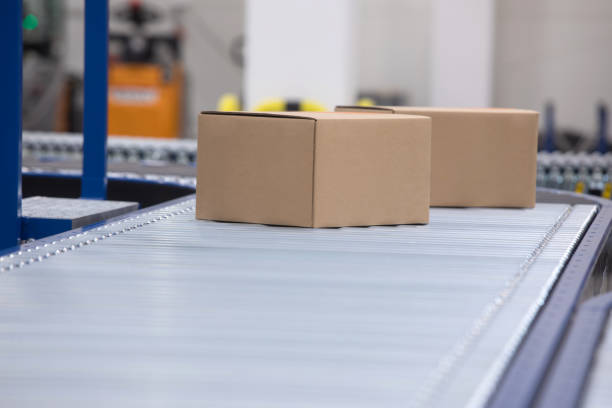 istock Packages delivery, packaging service and parcels transportation system concept, cardboard boxes on conveyor belt in warehouse 1138839193