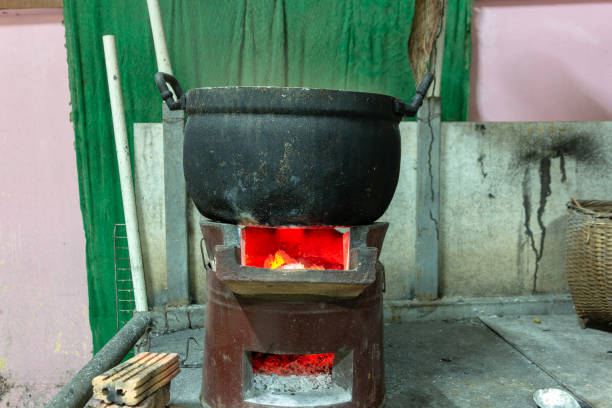 istock Cooking aluminum pot boiling on charcoal burning stove. 1138840216