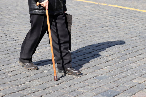 istock Old man walking with a cane on a street 1138840575