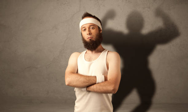 istock Skinny man with musculous shadow 1138840667