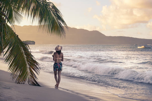 istock Attractive woman walk on the sandy tropical beach in sunset. 1138841900