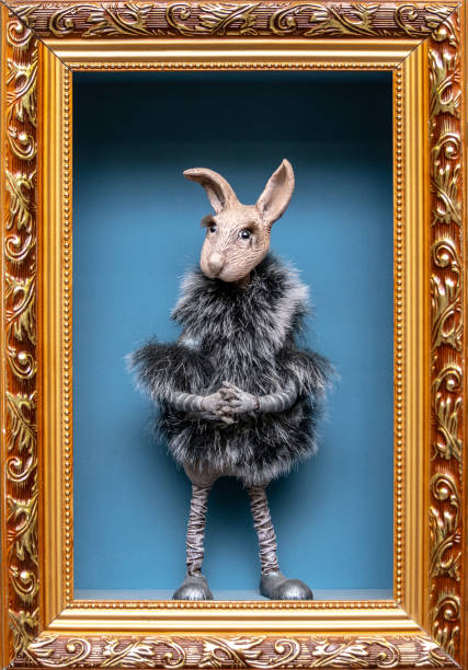 A doll rabbit in a fur coat in a picture frame