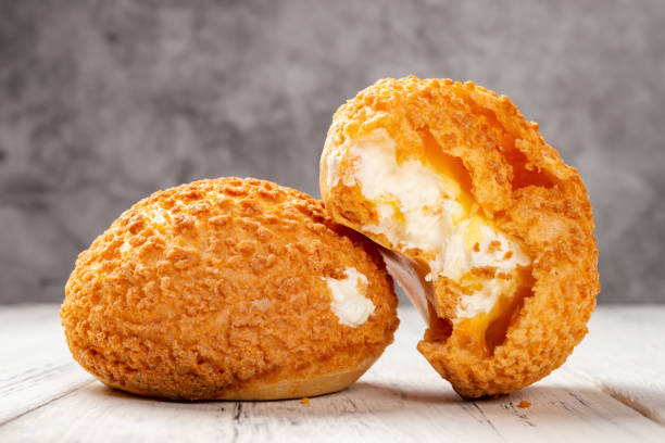 istock two pieces sweet puffs and one with a bite on a white wood table 1138844006