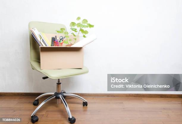 Box With Personal Items Standing On The Chair In The Officeconcept Of Moving Or Dismissal Stock Photo - Download Image Now