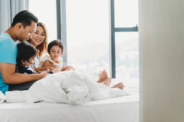 istock Happy family on the bed together 1138846095