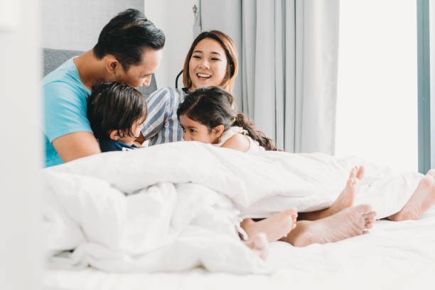 istock Happy family on the bed together 1138846101