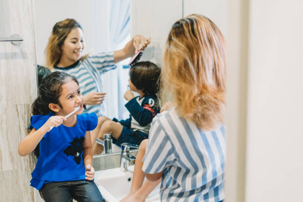 istock Brother and sister brushing their teeth with mom 1138846135
