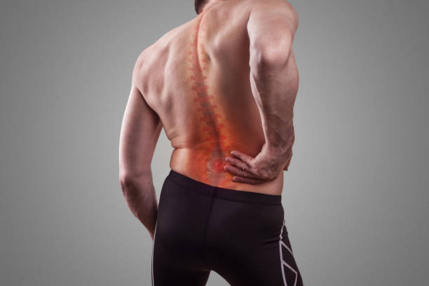 腰部背部への損傷。男は痛みに背中を抱えている。 - scoliosis ストックフォトと画像