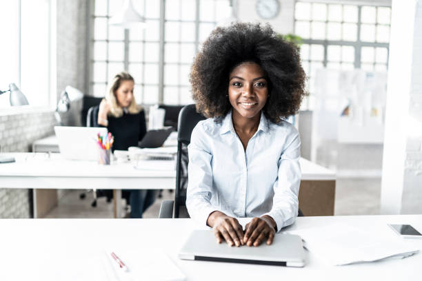 istock African woman working in modern office, looking at camera 1138850325